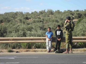 An Israeli soldier detains Palestinian boys aged 8 and 10 years. Photo by Maria Schaffluetzel