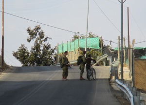 Israeli soldiers tell a young Palestinian boy he is not allowed to ride his bike in H2 in Hebron. Israelis can drive on this street but Palestinian are not allowed to
